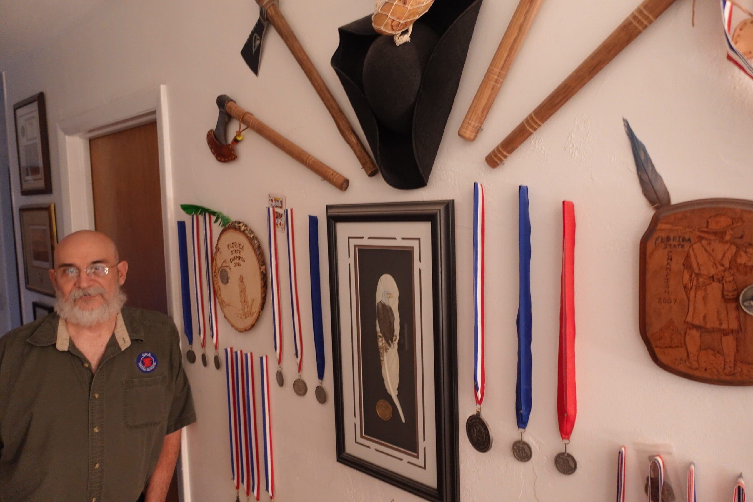 A wall with many medals and a picture on it