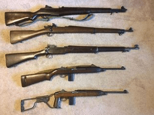 A group of different types of guns on the floor.