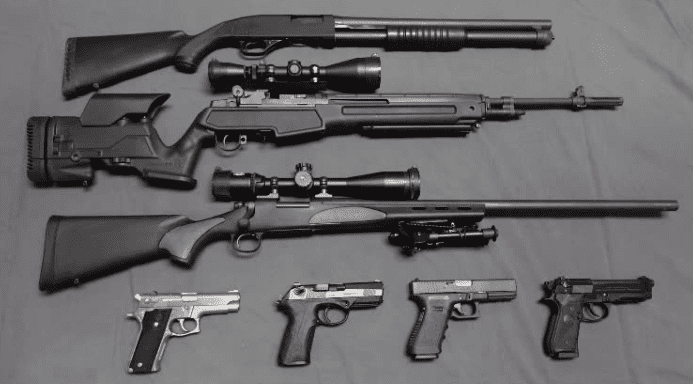 A table with several different types of guns.