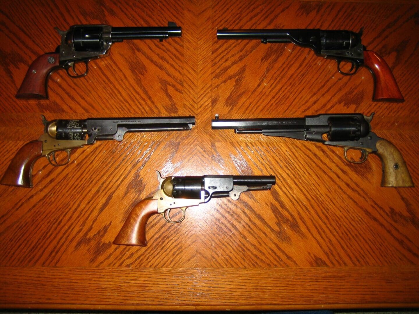Four guns are on a table with the top of the table.