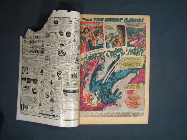 Vintage comic book open to a colorful page featuring Marvel Spotlight #9: the Ghost Rider story, on a dark background.