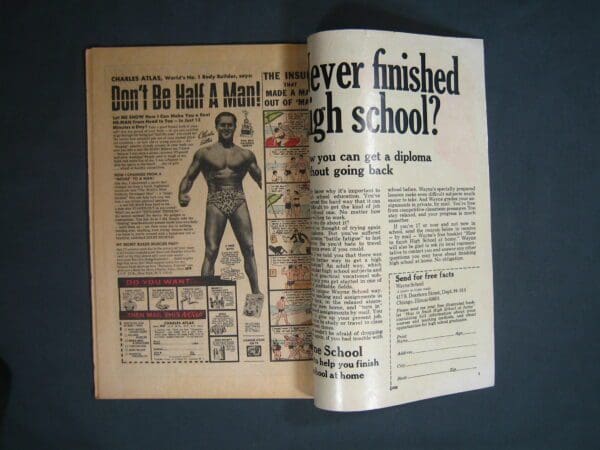 An open Marvel Spotlight #9 displaying an old advertisement with a muscular man and text promoting a high school diploma program.
