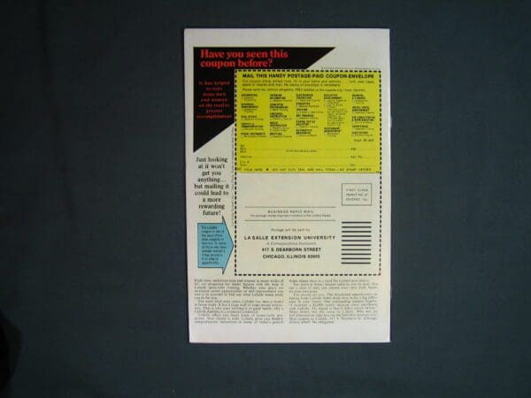 A printed advertisement for Ghost Rider #13 or informational flyer with a yellow coupon on a black background placed on a dark surface.